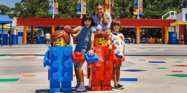 Family posing next to LEGO Minifigure statues