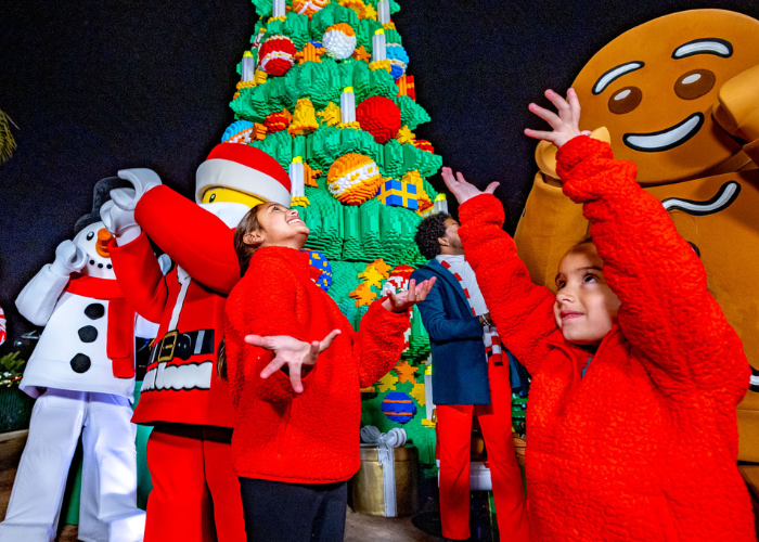 Kids interacting with LEGO characters during a holiday celebration at LEGOLAND Resort, surrounded by festive decorations