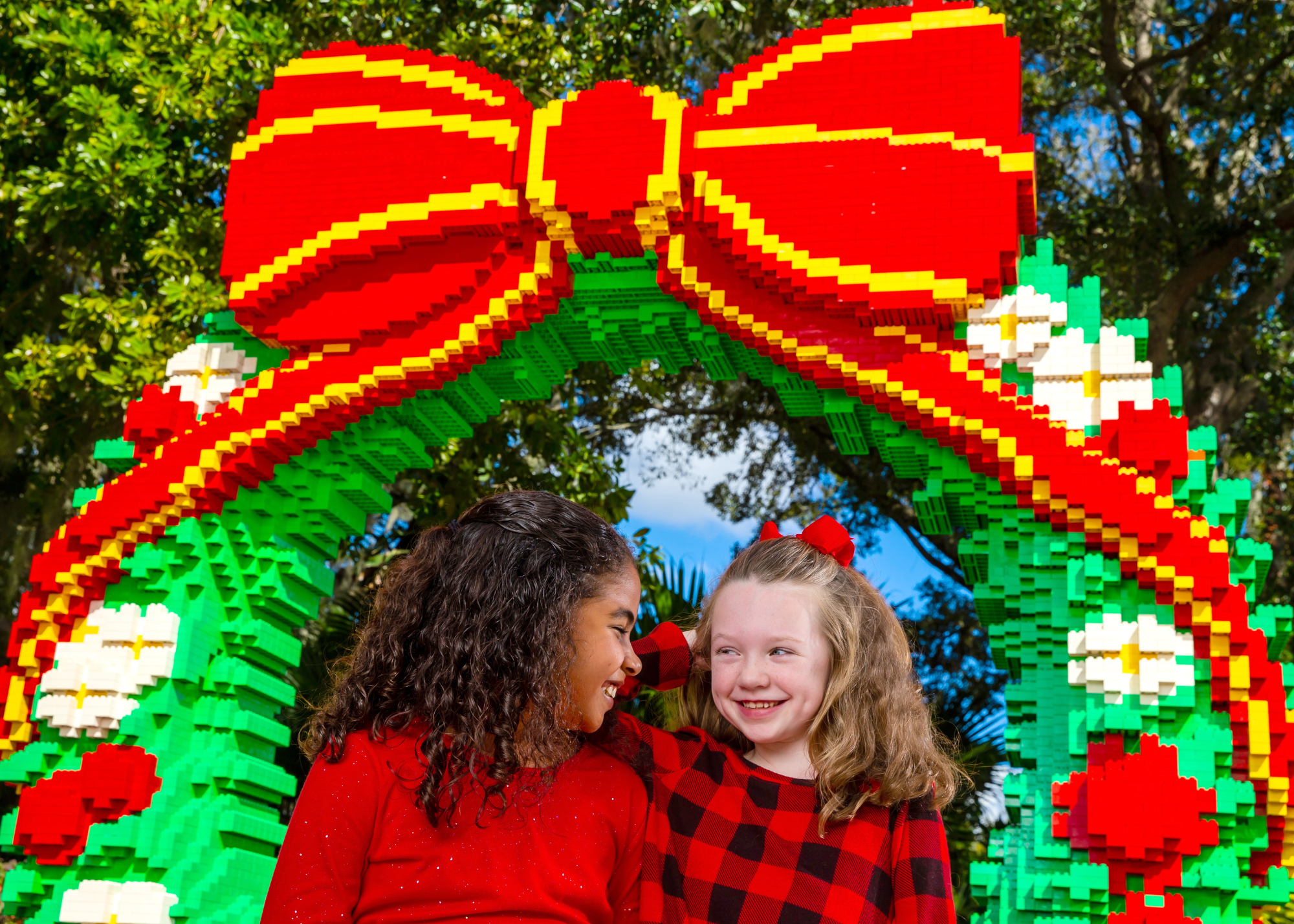 Two girls posing in front of holiday-themed LEGO decorations at LEGOLAND Florida