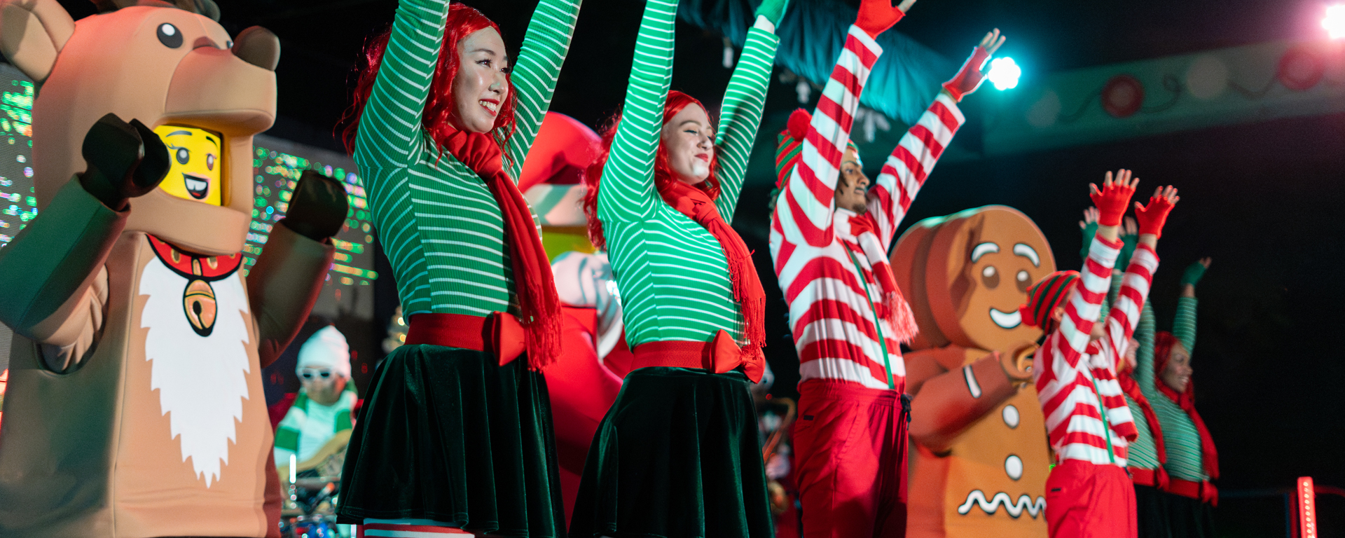 Holiday performers in festive costumes with LEGO reindeer and gingerbread characters at LEGOLAND Resort