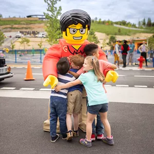 Tourist Tom welcomes a group of kids to LEGO CITY with a big hug